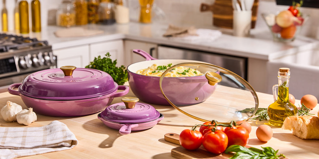 Larder & Vine purple cookware set on a kitchen counter with ingredients and kitchen tools.