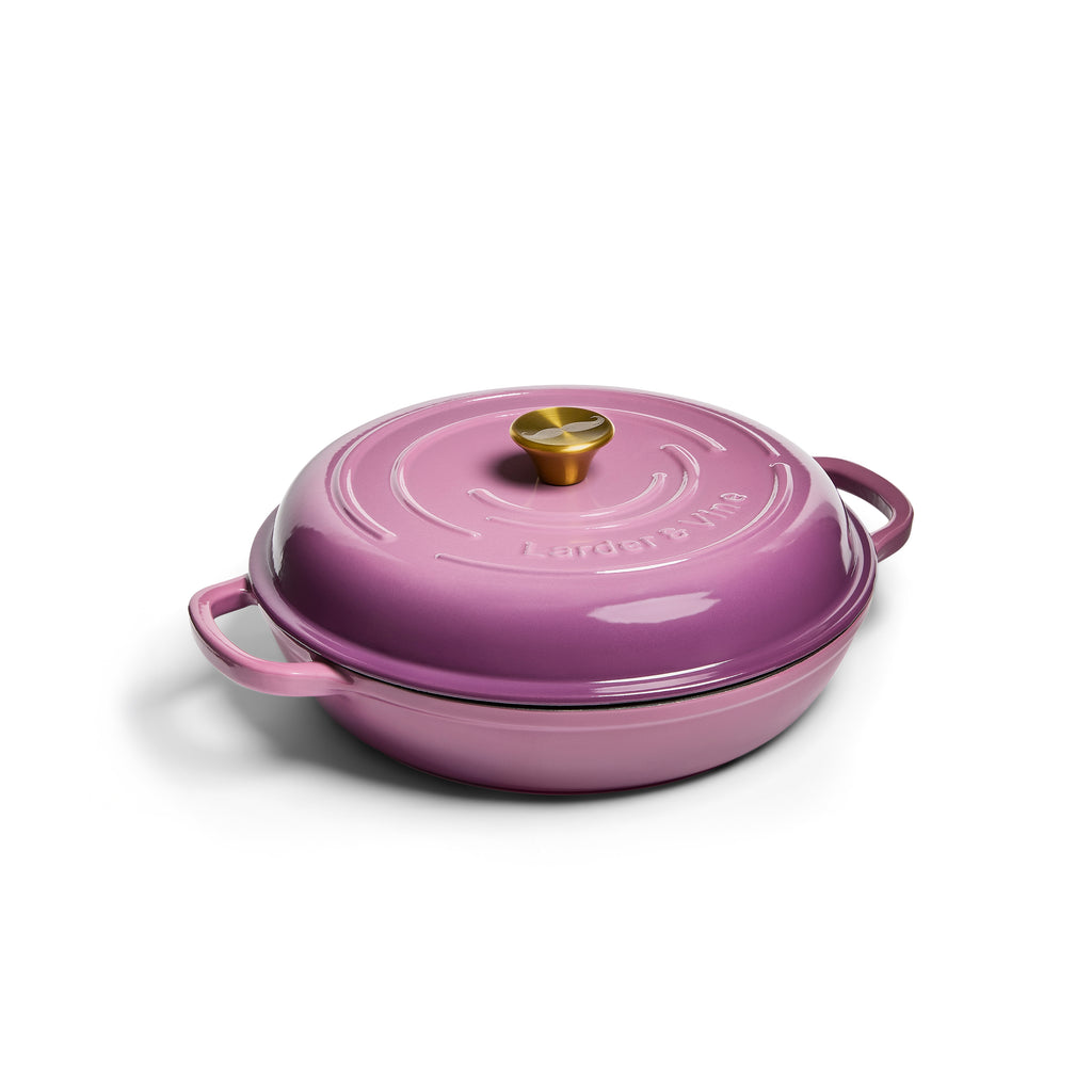 Purple enameled cast iron cookware with a lid on a white background