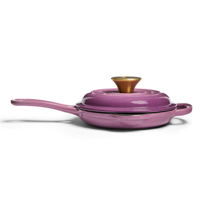 Purple frying pan with a lid on a white background